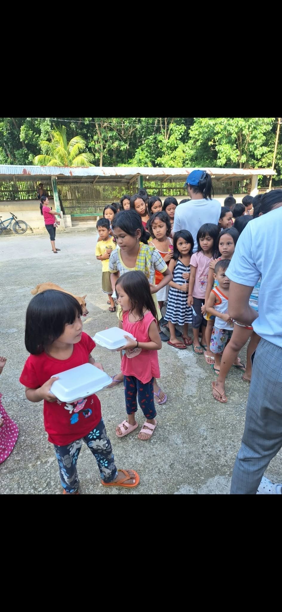 Children receiving food outdoors