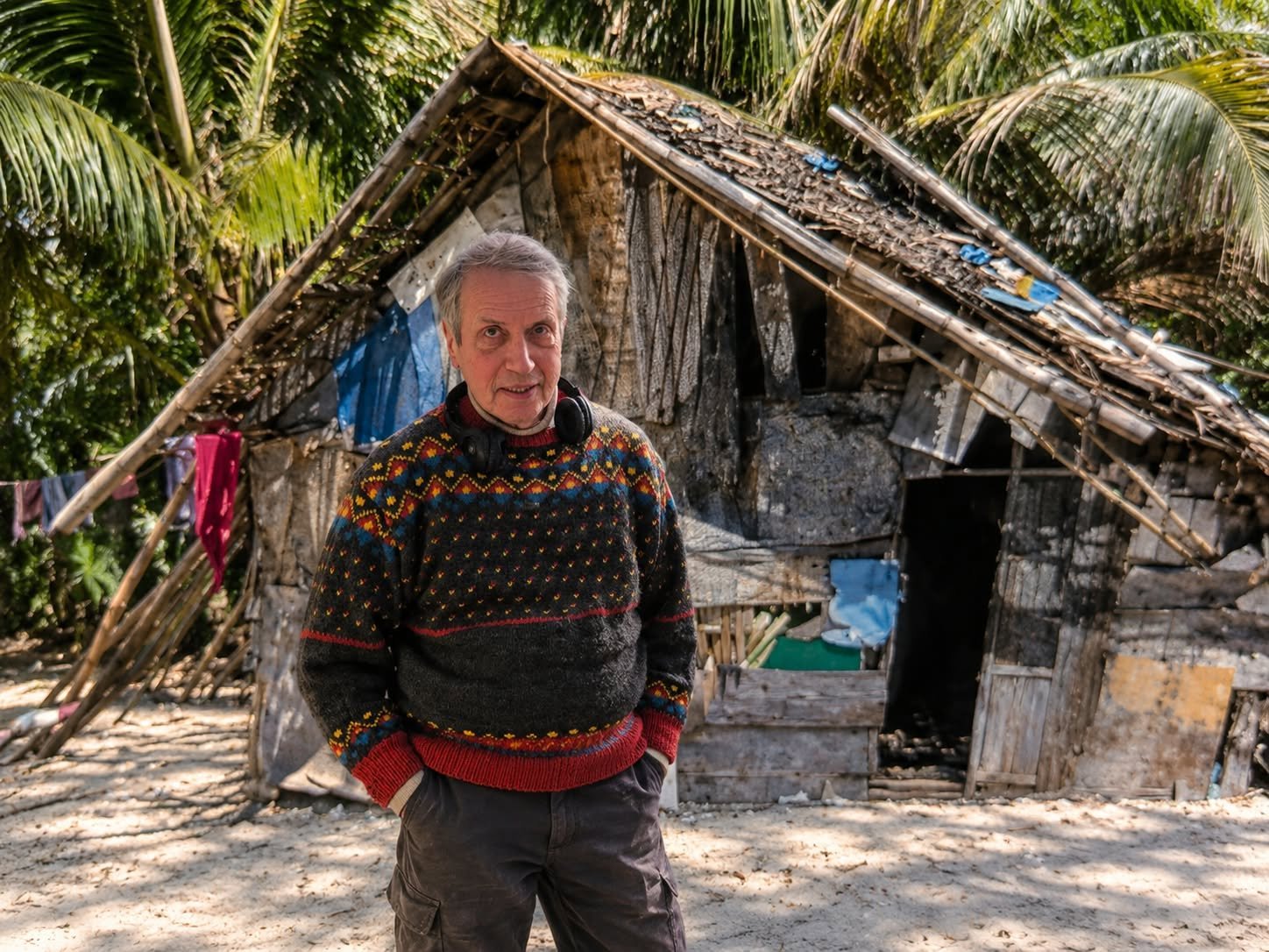 A person standing outside a small wooden home