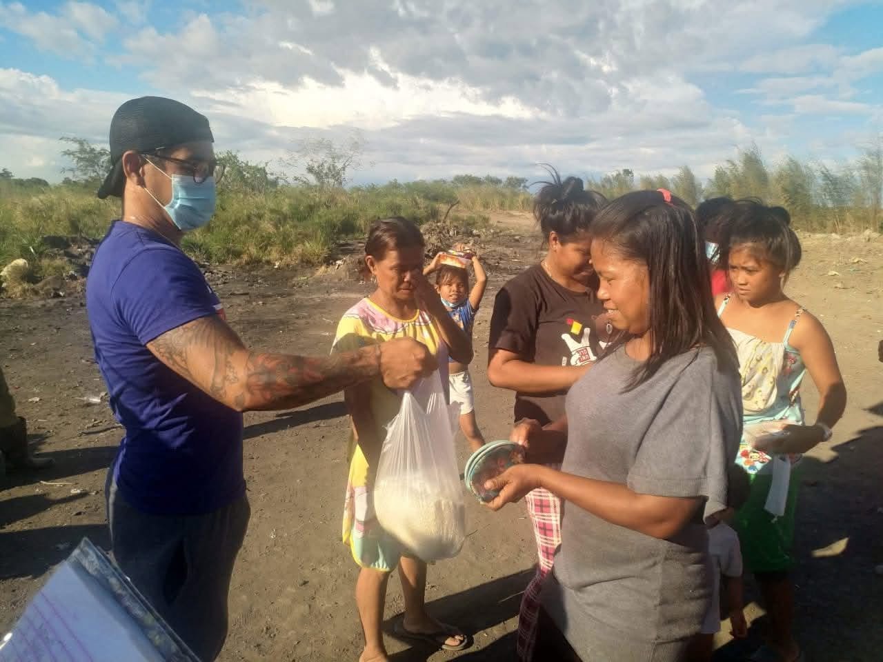 A volunteer handing a food package to a woman