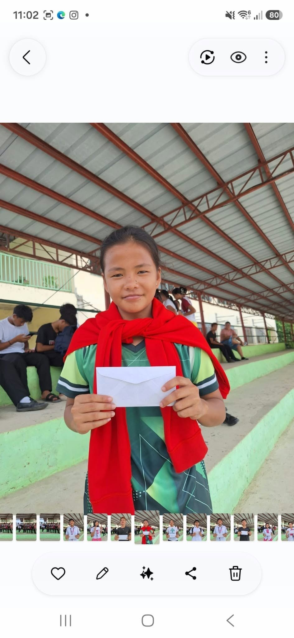 A student holding an envelope at a covered school venue